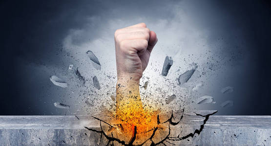 手触击剧烈并且打破石墙照片