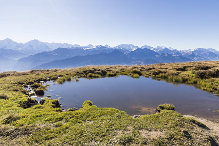 秋天风景在 Niederhorn 与一个池塘在前景和阿尔卑斯在背景在一个美丽的秋天天在瑞士