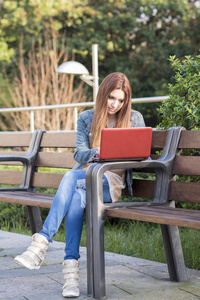 student brbara dator och sitta p bnken i parken