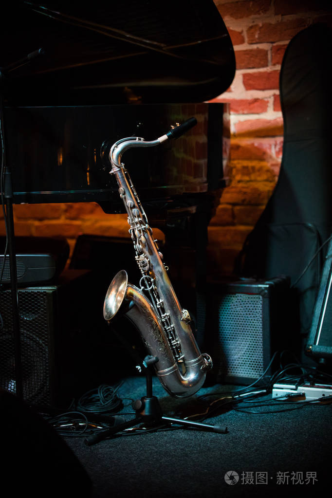 美丽的萨克斯站在舞台上的爵士乐酒吧