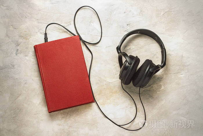 书和耳机连接到它在白色石头背景.概念电子书