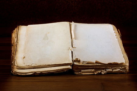 打开老的书与老式木制的桌子上文本的空白页