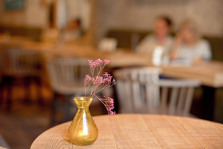 咖啡厅桌上有花的小乡土花瓶