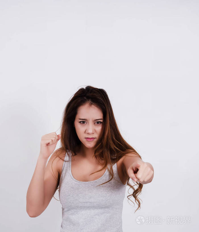 脸上带着不悦的美女, 她举起手准备冲拳, 生气的感觉.