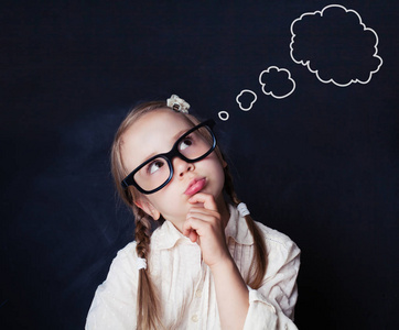 小女孩在课堂上有疑惑和想法.女童画像黑板上的言语云泡照片