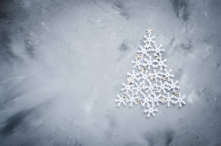 圣诞节贺卡与地方为您的文本。装饰 snowflakers 在灰色背景下圣诞树的形式奠定