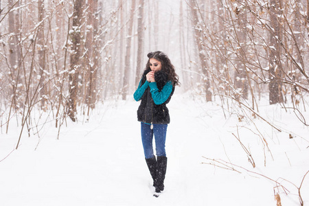 美丽的年轻妇女走在冬天下雪自然