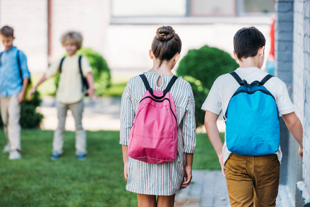 学校花园 bakpacks 行走学生的后视观