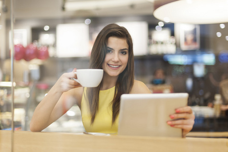 咖啡馆与数字平板电脑的女人