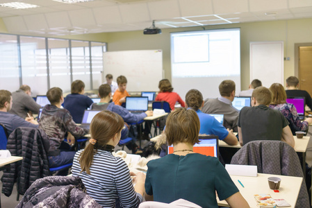 人们坐在电脑培训课的后方图片