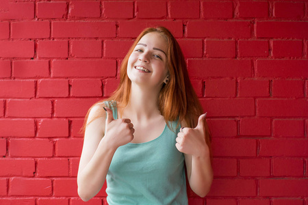 愉快的微笑红头发的妇女显示竖起大拇指