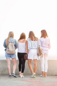 四妇女站在后面, 讨论自然的事情。夏天在公园散步