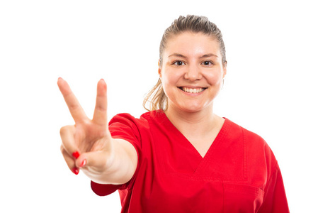 身穿红色磨砂的年轻医护护士肖像显示在白色背景上与 copyspace 广告区隔离的和平标志