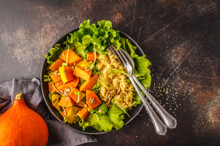 温暖的藜麦和南瓜沙拉在一个白色的盘子。健康素食主义者食品概念, 饮食食品