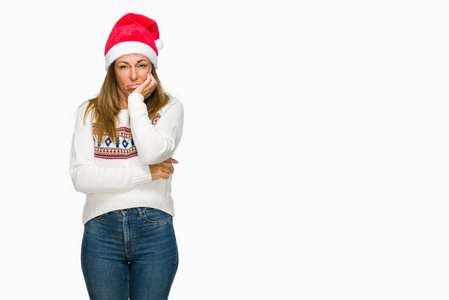 中年成年妇女穿着冬季毛衣和 chrismat 帽子在孤立的背景认为看起来疲惫和厌倦与交叉的手臂抑郁症的问题