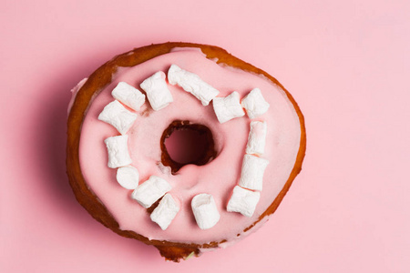 粉色甜甜圈和棉花糖粉红色甜甜圈的股票图像。粉红色背景上的甜甜圈。在粉红色背景下分离的甜甜圈