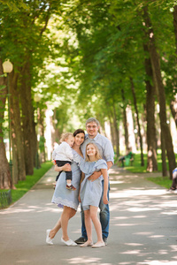 愉快的家庭与二个孩子在公园享受时间