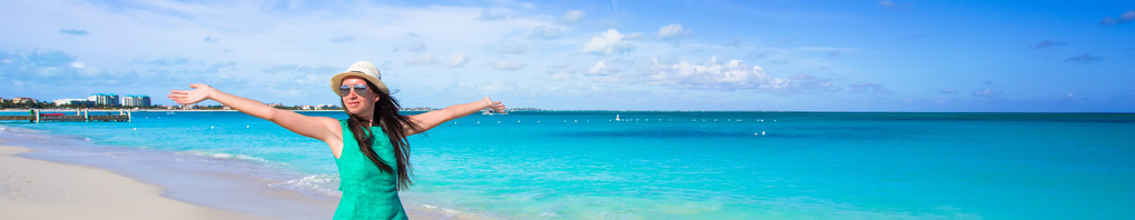 年轻快乐的女人，在她暑假期间的海滩上