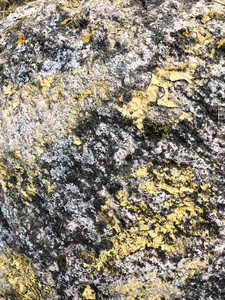 天然天然雕刻的质地坚硬粗糙粗糙的粗纹理矿物灰褐色石卵石在岩石的墙壁上。石材背景