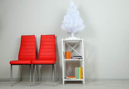 美丽的内部，与现代色彩的椅子，在背景墙上的木架子上的书