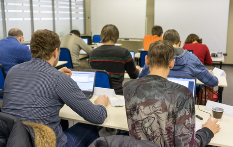 人们坐在电脑培训课的后方图片
