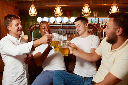四英俊的人一起喝啤酒在酒吧无比杯子照片