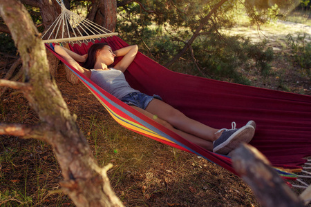 派对露营在森林里睡觉的女人。她放松