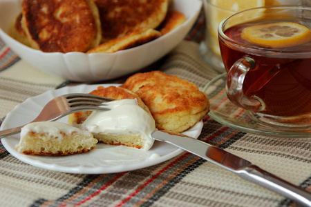 煎饼与酸奶油和一杯茶吃早饭