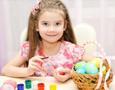 可爱的小女孩画五彩缤纷的复活节彩蛋