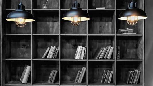 黑白照片。图书馆。书架上有书和三个燃烧的灯。很少有书。理念 图书馆教育阅读