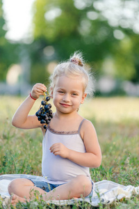夏天公园里吃葡萄的可爱小女孩