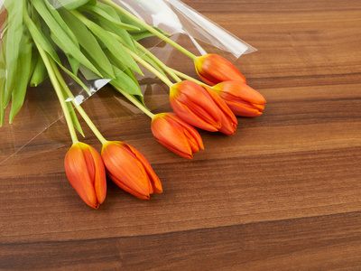 红色郁金香花在桌子上，背景