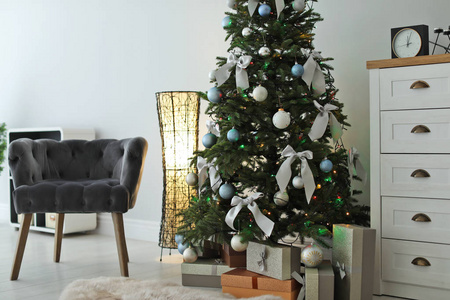 时尚的客厅内饰装饰圣诞树和舒适的扶手椅
