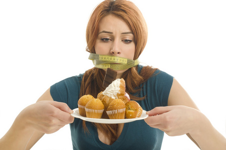 在她的嘴不能吃所有的糖果和糖,有很多曲奇在盘子上一厘米的女人照片