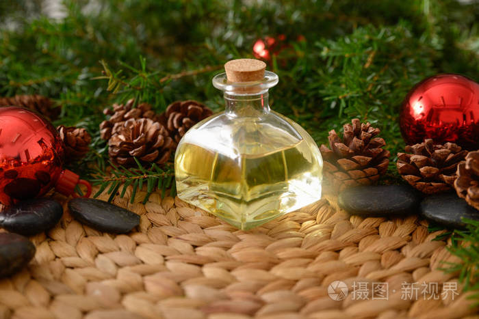 在柳条编织垫垫上用油和石头的圣诞冷杉树