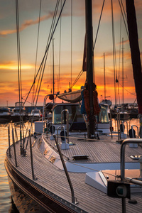 帆船与木甲板站立在海洋在美丽的日落