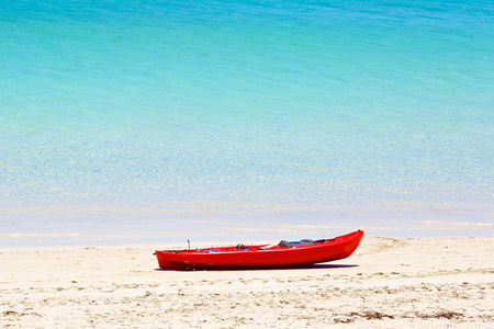 在沙滩上的红色独木舟