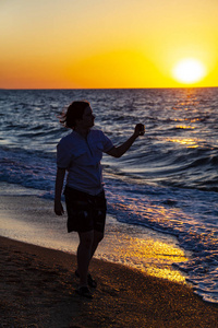 少年用行动照相机日落的海
