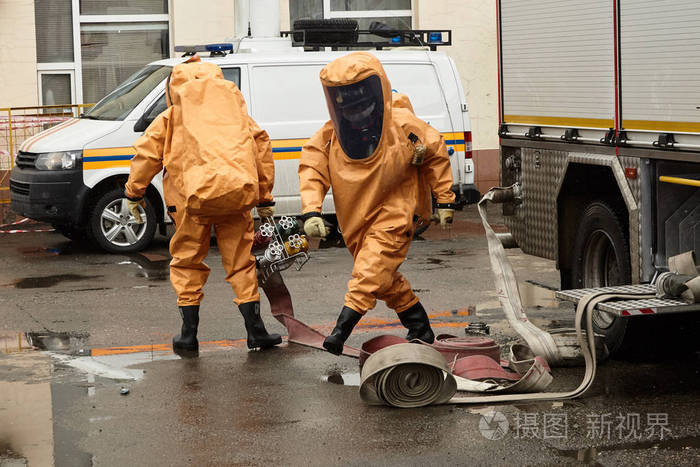 救援人员在胶囊适合解开消防软管泵水在感染区