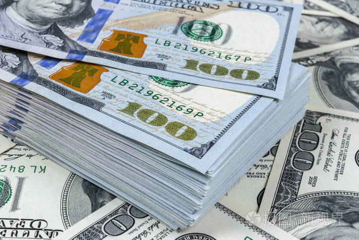 一叠100美元的钞票成堆的现金在百元钞票成堆的百元钞票的背景财务