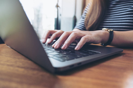 企业女性手上的特写图像在笔记本电脑键盘上工作和打字