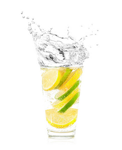 柠檬和石灰片在玻璃中分离在白色。掉进水里的水果飞溅