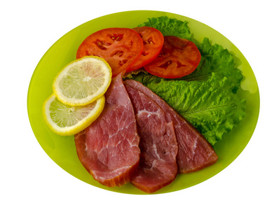 火腿配沙拉, 西红柿和柠檬放在盘子里。火腿在白色背景下分离. 火腿顶部视图