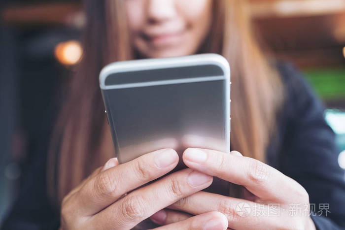手持,使用和看智能手机的女性特写图像