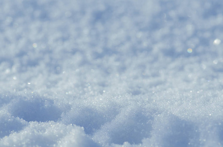 自然的冬季背景。雪亮的漂泊。冬雪背景纹理。雪与太阳一起闪耀