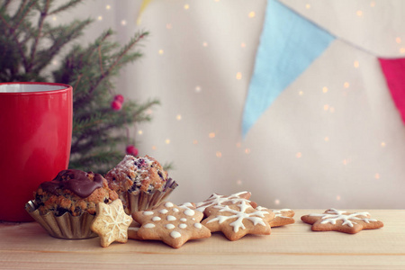 在红色杯子和绿色圣诞树寒假的背景下, 用浆果和饼干来庆祝的巧克力纸杯蛋糕会满足人们的胃口
