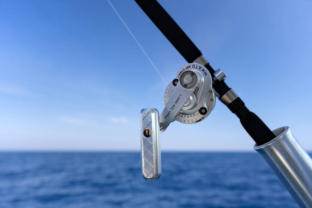 渔业日在蓝色海洋的海水船钓鱼竿。成功的捕鱼概念