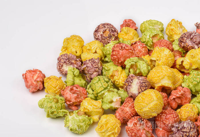 一堆五颜六色的焦糖爆米花仍然生活在白色木桌上五颜六色的爆米花假日