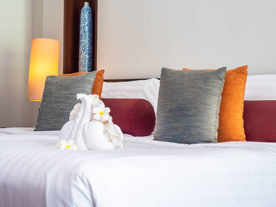 舒适的枕头在床上与灯装饰在旅馆卧室里