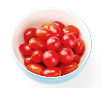 在白色背景上的碗中的新鲜樱桃番茄。